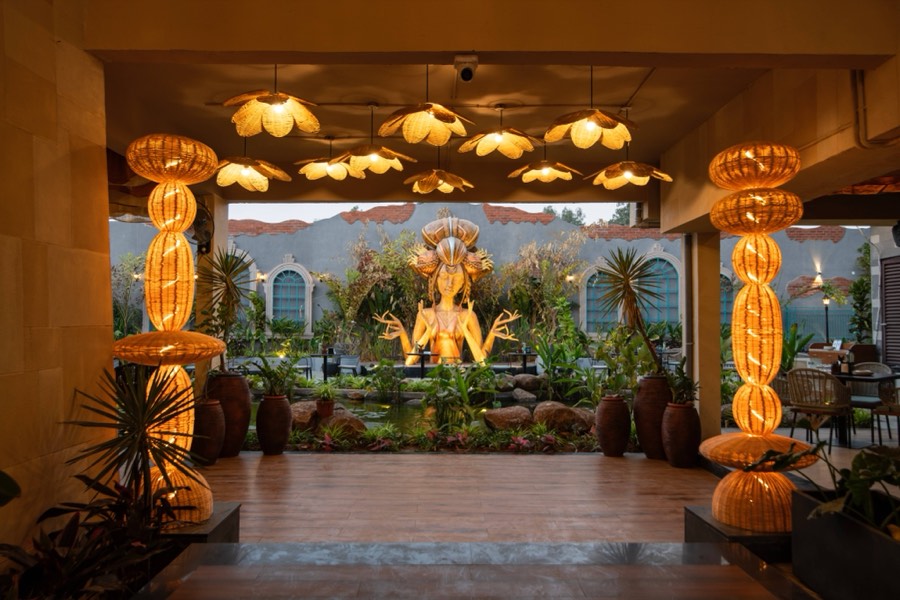 Rattan lotus lights framing the goddess statue at dusk